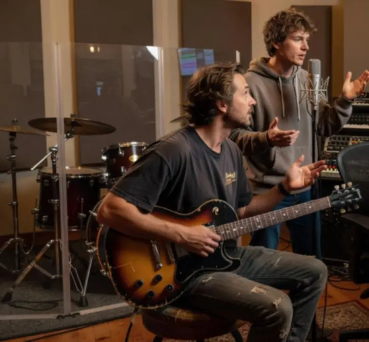 Creative collaborators from diverse genres working together in a music session